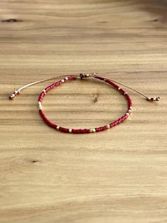 This dainty dark red and gold beaded bracelet adds a subtle pop of color to any outfit. Made with high-quality beads and an adjustable closure for the perfect fit, this bracelet is both stylish and comfortable. Perfect for everyday wear or as a thoughtful gift. ~Will fit wrists from 5 3/4" - 7". ~Carefully hand crafted with premium Miyuki Delica glass seed beads, and tiny 14k gold plated cube beads. ~Comes neatly packaged for you or ready to gift. ~Recommended care:  To keep your handmade jewelr Red And Gold Beaded Bracelet, Tiny Bead Bracelet, Red Beaded Bracelet, Miyuki Bracelet, Cube Beads, Seed Bead Bracelet, Gold Bead Bracelets, Christmas Bracelet, Red Bracelets