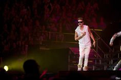 two men in white outfits on stage at a concert