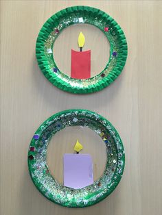 two paper plates with candles on them are sitting on a table