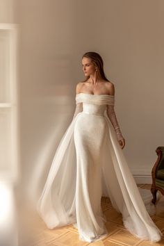 a woman in a white dress is standing on the floor with her arms spread out