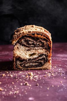 a close up of a piece of bread on a purple surface with sprinkles