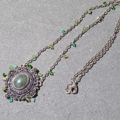 This vintage Fratelli Peruzzi sterling brooch has been repurposed into a pendant and paired with an assortment of green accent gems and oxidized sterling chain. The brooch has a center stone that is an understated blueish green. I don't know what kind of stone it is. It measures 14mm x 10mm. The setting is beautiful filigree...very intricate. The pendant measures 1.5" x 1.25".  I have added various green gems, (chrome diopside, peridot, chrysoprase) to the brooch and the oxidized necklace chain to create a delicate, easy to wear necklace. 19" in length. Sterling findings. Ships via USPS First Class Mail. Thank you for shopping Teece Torre Jewelry. Sterling Silver Pendant For Vintage Collection, Sterling Silver Pendant Necklace For Vintage Collection, Sterling Silver Pendant Necklaces For Vintage Collection, Green Gemstone Medallion Jewelry, Green Medallion Jewelry With Large Pendant, Green Oxidized Pendant Necklace, Elegant Oxidized Finish Necklace Vintage Collection, Green Medallion Pendant Jewelry, Ornate Green Pendant Necklace