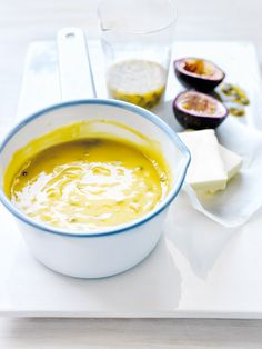 a white plate topped with soup next to an avocado