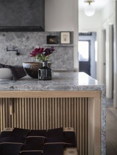 a kitchen with marble counter tops and an island in front of the stove top oven