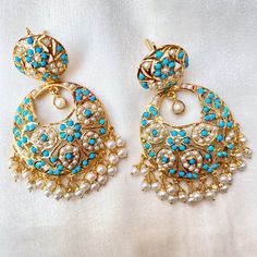 Pair of earrings in gold plated sterling silver. It has been embellished with precious freshwater pearls and turquoises. The earrings are light and comfortable to wear at just 28gms per pair. Hyderabadi Jewelry, Vintage Turquoise Jewelry, Bridal Jewelry Sets Brides, Gold Jewelry Simple Necklace, Peridot Jewelry, Chandbali Earrings, Indian Jewellery Design Earrings, Antique Jewelry Indian, Vintage Style Earrings