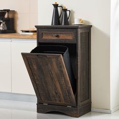 a wooden cabinet with an open door in a kitchen next to a counter and coffee maker