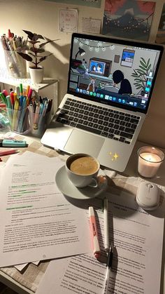 an open laptop computer sitting on top of a desk next to a cup of coffee