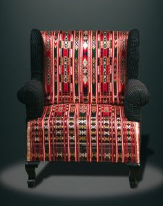 a red and black patterned chair against a dark background