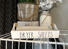 there is a sign that says dryer sheets on the shelf next to some flowers