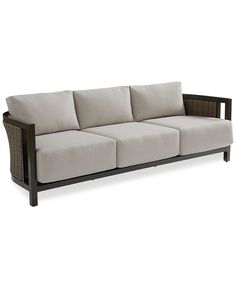 an outdoor sofa with four cushions and wicker back rests against a white background,