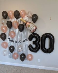 balloons and streamers are arranged in the shape of an 30th birthday sign with a bottle of champagne