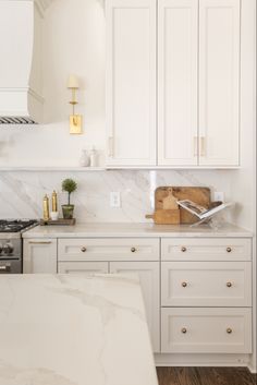 a kitchen with marble counter tops and white cabinets