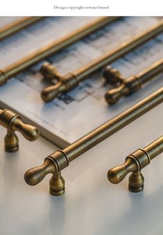 four brass handles on a metal surface