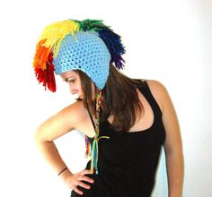 a woman wearing a crocheted hat with multicolored feathers