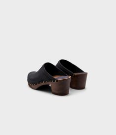 Made by skilled artisans in Sweden, these black nubuck clog mules feature a high heel and eye-catching stud detailing on the sides. From date nights to ladies' nights out, Rome delivers unparalleled style and confidence. Clog measurements:Heel height: 2 5/8” (6.5 cm)Toe height:﻿ 1 1/2″ (3.8 cm) Fit:NarrowLeather:Nubuck leatherClogs consist of:Base: European Lime Wood Sole: Rubber sole Fastening: Brass studs Suede Slip-on Mules With Wooden Heel, Suede Clogs With Stacked Open Heel, Suede Clogs With Stacked Heel And Open Heel, Sandgrens Clogs, Clog Mules, Studded Clogs, Heeled Mule, Cork Sandals, Wooden Clogs