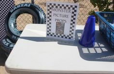 a table topped with blue vases next to tires and a sign that says monster picture props