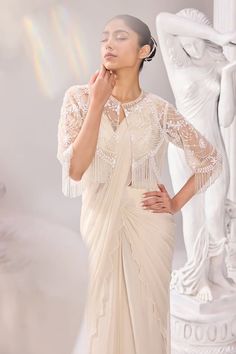 Off-white pre-draped saree with scallop border. Paired with blouse and pearl, bead embroidered tassel jacket. - Aza Fashions Elegant White Pre-draped Saree With Sheer Dupatta, Elegant White Designer Pre-draped Saree, Elegant Blouse With Draped Sleeves For Reception, Elegant Pre-draped Saree With Cape Sleeves For Wedding, Elegant Side Open Pre-draped Saree For Wedding, Elegant Pre-draped Saree With Cape Draped Sleeves, Elegant White Pre-draped Saree In Traditional Style, Elegant White Pre-draped Saree With Traditional Drape, Elegant White Draped Blouse