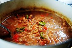 a pot filled with beans and vegetables on top of a stove