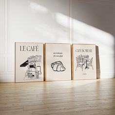 three framed art prints sitting on top of a wooden floor