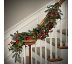 a christmas garland on the banister with holly and berries