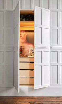 an open closet with drawers and doors on the inside, revealing a woman's face