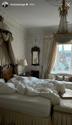 a large bed sitting in a bedroom next to a window with curtains on the windowsill