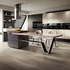 a modern kitchen with an island table and stairs in the backround, surrounded by white cabinets