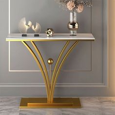 a console table with two vases and flowers on it in a room that has grey walls