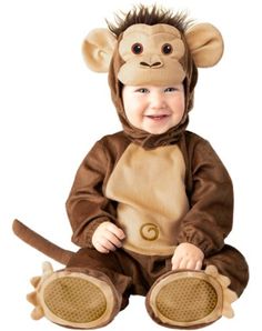 a baby in a monkey costume sitting on the ground