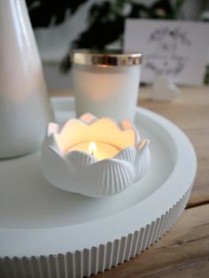 a white candle sitting on top of a wooden table