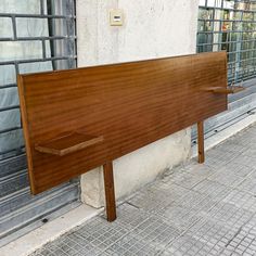 a wooden bench sitting on the side of a building