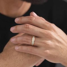 a close up of a person wearing a wedding ring on their finger and holding the other hand