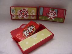 two boxes with candy in them sitting on a table next to snowflakes