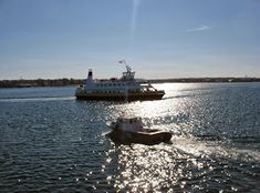 a boat traveling across a large body of water next to another boat in the distance