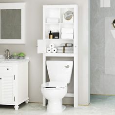 a white toilet sitting in a bathroom next to a sink and a shelf filled with towels