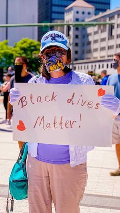 a person holding a sign that says black lives matter