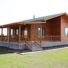 a small wooden cabin sitting on top of a lush green field