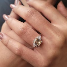 a woman's hand with a ring on it and a yellow diamond in the middle