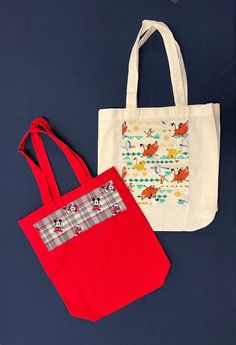 One of each Tote Bag design is available, featuring various cartoon characters: Lion King, Daniel Tiger, Minnie and Mickey Mouse together on plaid, Bluey, Sonic and others. All totes 100% cotton, except Aqua which is Polyester.  Size: 13.5" x 13.5" x 4" (4"gusset) Washable in cool or cold water, hang dry or tumble dry low. Iron on low or medium setting.  Details: Minnie Mickey Plaid, 13.5" x 13.5" x 4"  Red tote bag shown in photo. Also available in other colors: Ivory (cream) color tote bag or Fun Multicolor Bag With Character Print, Playful Multicolor Bags With Character Print, Multicolor Character Print Bags For Daily Use, Playful School Bag With Character Print, Playful Character Print Multicolor Bag, Playful Multicolor Character Print Bags, Disney Style Gift Bag, Rectangular Shape, Cartoon Character Print Bags For Everyday Use, Fun Everyday Bags With Cartoon Print