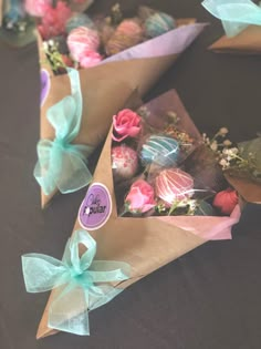 there are many flowers and chocolates wrapped in brown paper on the table with ribbons