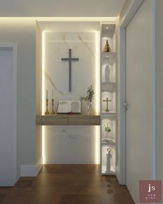 an empty room with a cross on the wall next to a shelf filled with books and candles