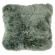 a gray furry pillow sitting on top of a white floor