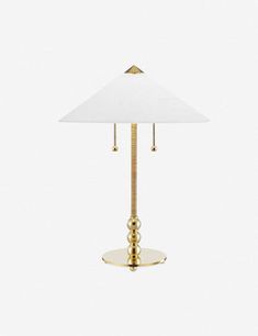 a lamp with a white shade on top of it and a gold base around the bottom