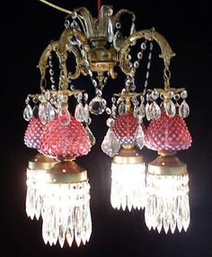 two chandeliers hanging from a ceiling in a dark room