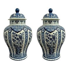 two blue and white vases sitting side by side on top of eachother