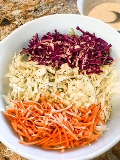 cabbage, carrots and coleslaw in a bowl with dressing on the side