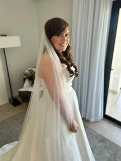 a woman in a wedding dress is posing for the camera with her veil over her head