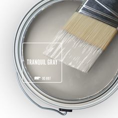 a paint can with a brush in it and the words trandul gray above it