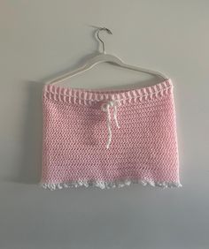 a pink knitted skirt hanging on a hanger