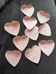 paper hearts with writing on them sitting on a couch